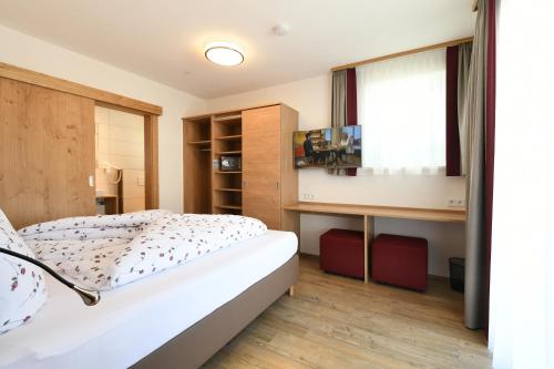カップルにあるFerienwohnungen Marmotのベッドルーム(ベッド1台、窓付)