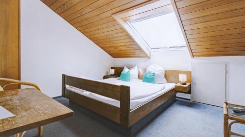 a bedroom with a bed and a skylight at Hotel Restaurant Austüble in Elchingen