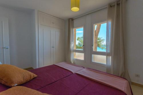 une chambre avec un grand lit et une fenêtre dans l'établissement Zeus Guardamar Seaview, à Miami Platja