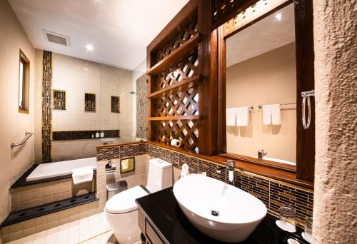 a bathroom with two toilets and a sink and a tub at Phra Singh Village in Chiang Mai