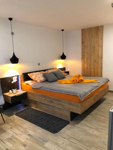 a bedroom with a large bed with orange pillows at Korošec Apartments and Wellness Centre in Mozirje