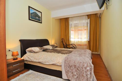 1 dormitorio con cama y ventana en Apartment S&T, en Tivat