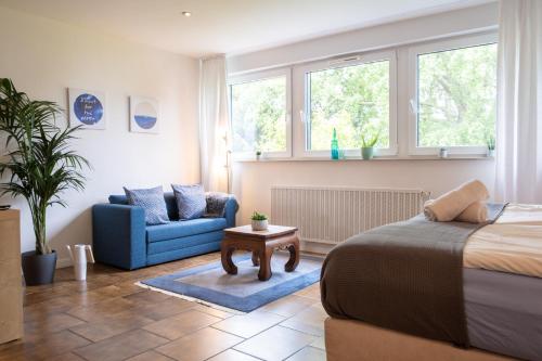 a bedroom with a bed and a couch and a chair at Helles Appartement mit eigenem Stellplatz in Oberhausen