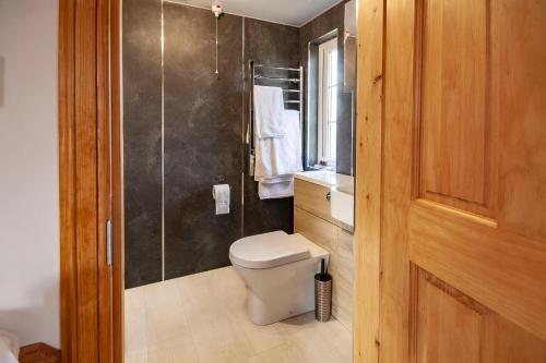 a bathroom with a toilet and a glass shower at Osprey lodge in Elgin