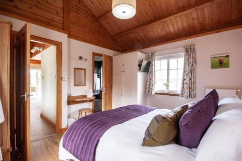a bedroom with a large bed with a wooden ceiling at Osprey lodge in Elgin