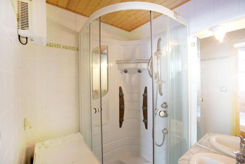 y baño con ducha de cristal y lavabo. en Appartement la Cabane d'Engaly, en Aragnouet