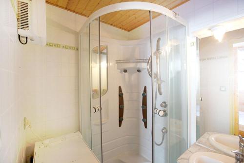 une douche en verre dans une salle de bain avec un lavabo dans l'établissement Appartement la Cabane d'Engaly, à Aragnouet