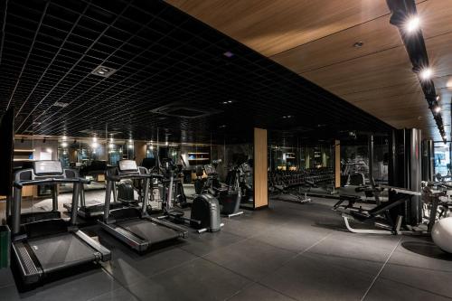 a gym with several treadmills and elliptical machines at The Key Premier Hotel Sukhumvit Bangkok in Bangkok