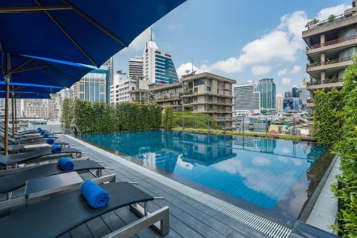 a swimming pool with a city skyline in the background at The Key Premier Hotel Sukhumvit Bangkok in Bangkok