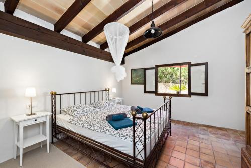 - une chambre avec un lit et un plafond en bois dans l'établissement Casa Sa Mata, à Artà