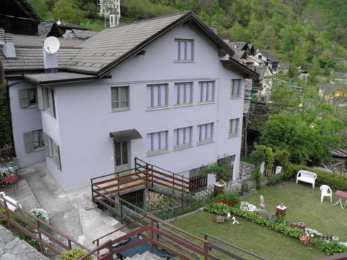 a large white house with a yard with a yard at Casa Vacanza PIZZO CAMINO in Calasca Castiglione