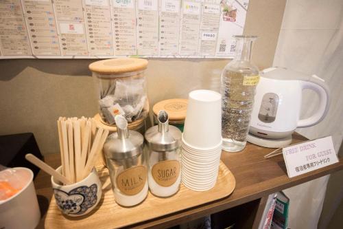 a wooden shelf with cups and utensils on a table at SHARIN in Kanazawa
