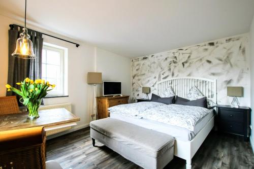 a bedroom with a white bed and a desk and a window at Landpension Bocka in Bocka