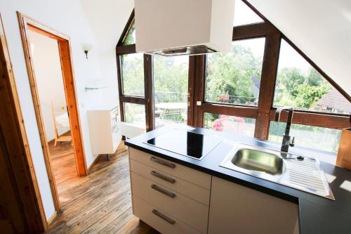 a kitchen with a sink and a large window at Landpension Bocka in Bocka