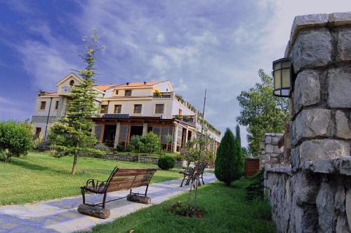 two benches in front of a large house at Hotel Aria in Podgorica