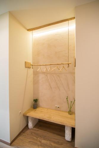 a wooden bench in a room with a wall at Ederlezi Boutique Hotel in Athens