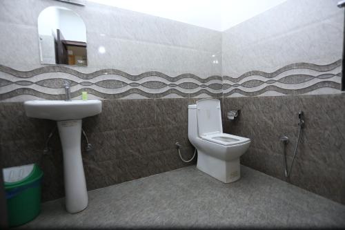 カトマンズにあるHotel Hemaのバスルーム(洗面台、トイレ、鏡付)