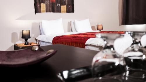 um quarto de hotel com duas camas e uma mesa em Villa Agapanthe em Fez