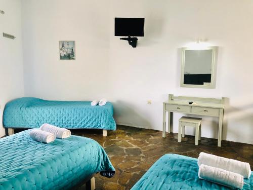 a room with two beds and a desk and a mirror at Delta Studios in Gerani