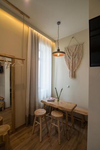 a dining room with a wooden table and stools at Ederlezi Boutique Hotel in Athens