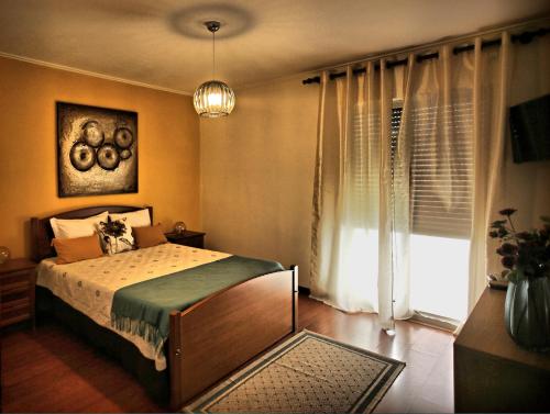 a bedroom with a bed and a large window at Canto da Maia Apartment in Ponta Delgada