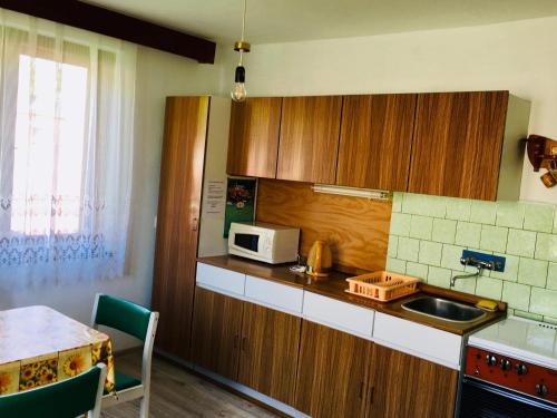 a kitchen with a sink and a microwave at Rodinný RETRO domček in Dolný Kubín