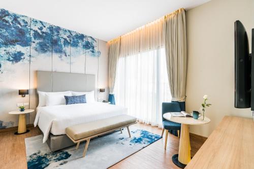a bedroom with a bed and a large window at The Key Premier Hotel Sukhumvit Bangkok in Bangkok