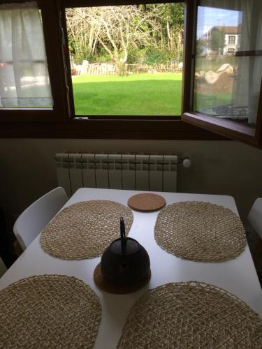 a table with hats on it with a window at La Llastra de Garaña in Llanes