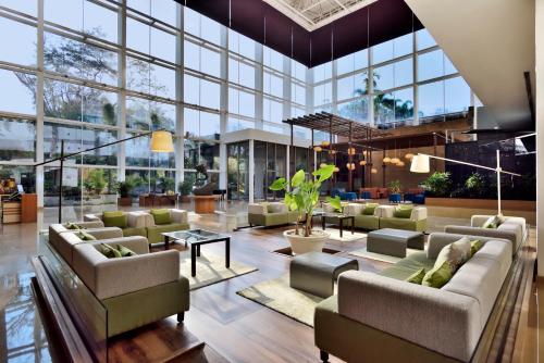 a lobby with couches and tables and windows at Radisson Blu Plaza Hotel Hyderabad Banjara Hills in Hyderabad