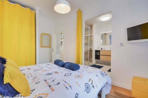 - une chambre avec un lit et un rideau jaune dans l'établissement Le splendide de Stanislas, à Nancy