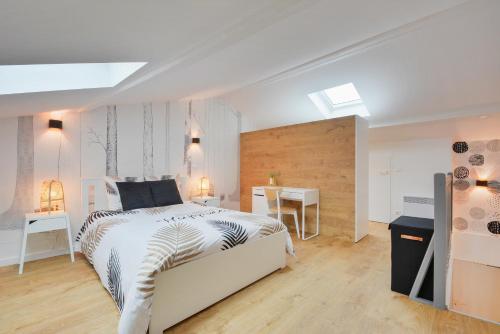 une chambre avec un grand lit et un bureau dans l'établissement Le Royal des Trois-Maisons, à Nancy