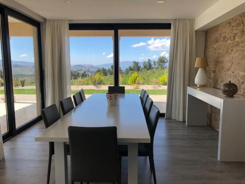 a dining room with a white table and chairs at Quinta BEMBOA Turismo Espaço Rural in Aricera