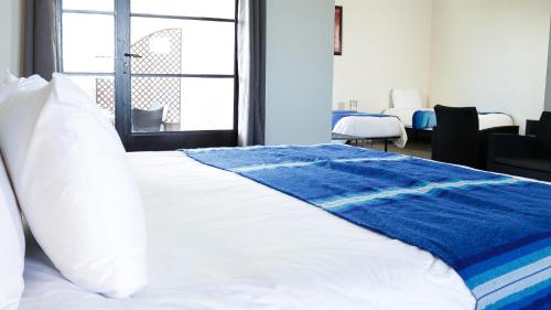 a bedroom with a bed with a blue blanket on it at Villa Agapanthe in Fès