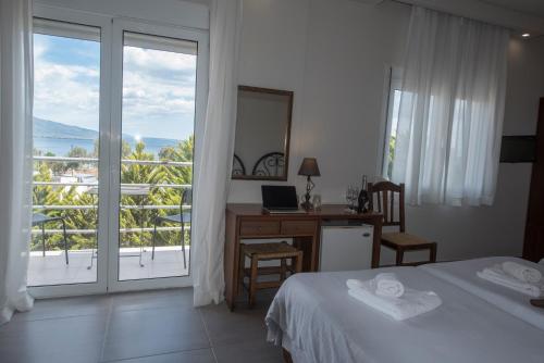 1 dormitorio con cama, escritorio y ventana en Filoxenia Hotel, en Volos