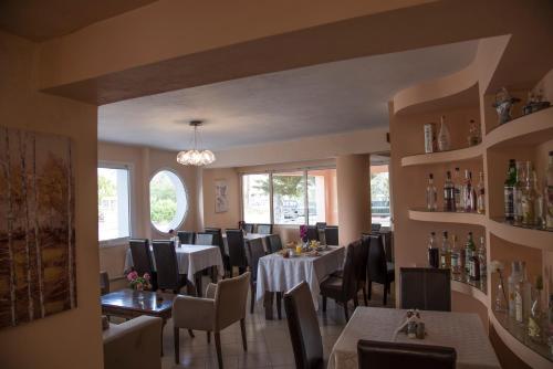 a dining room with tables and chairs in a restaurant at Filoxenia Hotel in Volos