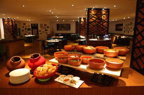 a table with many different bowls and plates on at Radisson Blu Plaza Hotel Hyderabad Banjara Hills in Hyderabad