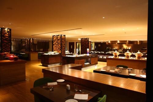 a restaurant with tables and counters and a buffet at Radisson Blu Plaza Hotel Hyderabad Banjara Hills in Hyderabad