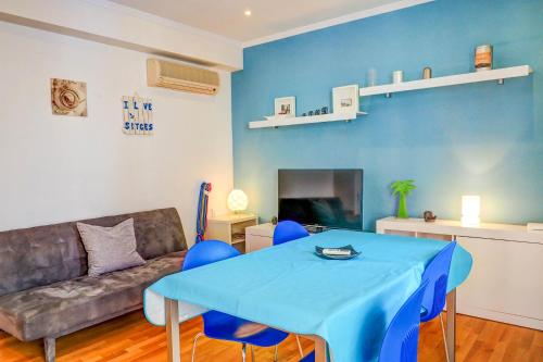 ein Wohnzimmer mit einem blauen Tisch und einem Sofa in der Unterkunft Aire Apartment by Hello Homes Sitges in Sitges