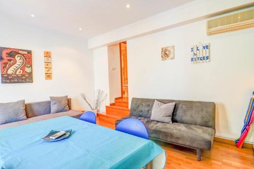 ein Wohnzimmer mit einem Sofa und einem Tisch in der Unterkunft Aire Apartment by Hello Homes Sitges in Sitges