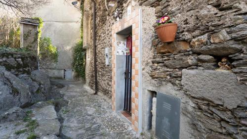 a stone building with a door and a flower pot at La casa della Cindy in Dervio