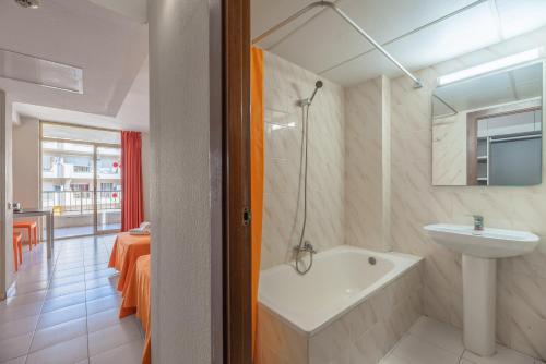 La salle de bains est pourvue d'un lavabo et d'une baignoire. dans l'établissement Salou Pacific Rentalmar, à Salou