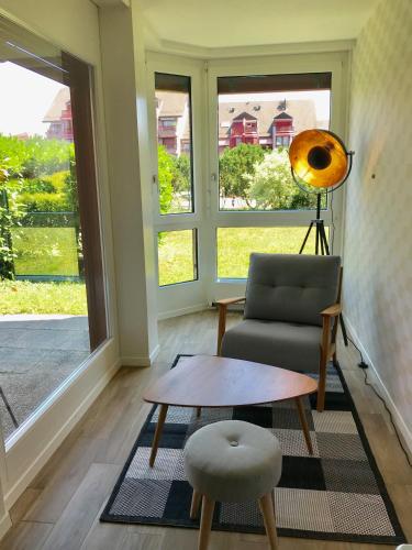 a living room with a chair and a table at Large Studio Near Epfl And Lausanne City Center in Ecublens