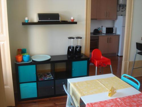 a kitchen with a table and a red chair at CoolHostel in Porto