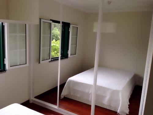 a bedroom with a white bed and a mirror at Quinta Parque Nacional Peneda Geres in Paradamonte