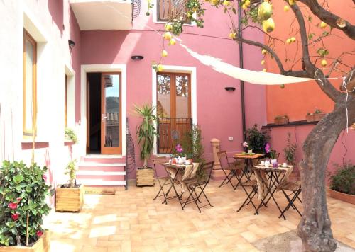 a pink house with tables and chairs in front of it at La Perla del Sud in Teulada