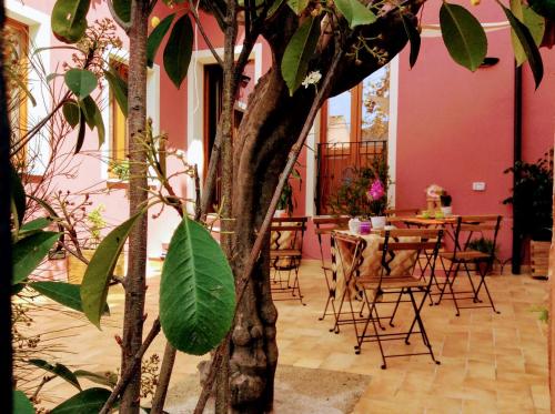 a room with a table and chairs and a tree at La Perla del Sud in Teulada