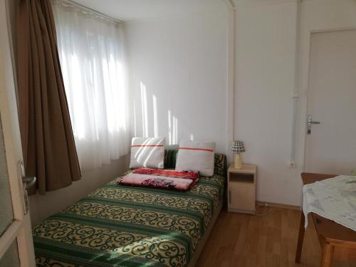 een bed in een kamer met een raam bij Bartók Apartmanház in Balatonszárszó