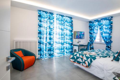 een slaapkamer met blauwe gordijnen en een bed en een stoel bij YourHome - Unica Luxury Apartment in Castellammare di Stabia