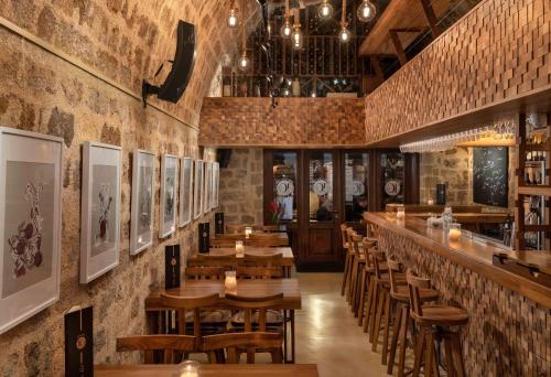 a restaurant with wooden tables and chairs and a bar at 10GR Boutique Hotel & Wine Bar in Rhodes Town