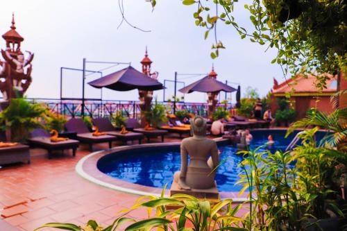 a woman sitting in the pool at a resort at Okay Guesthouse Siem Reap in Siem Reap